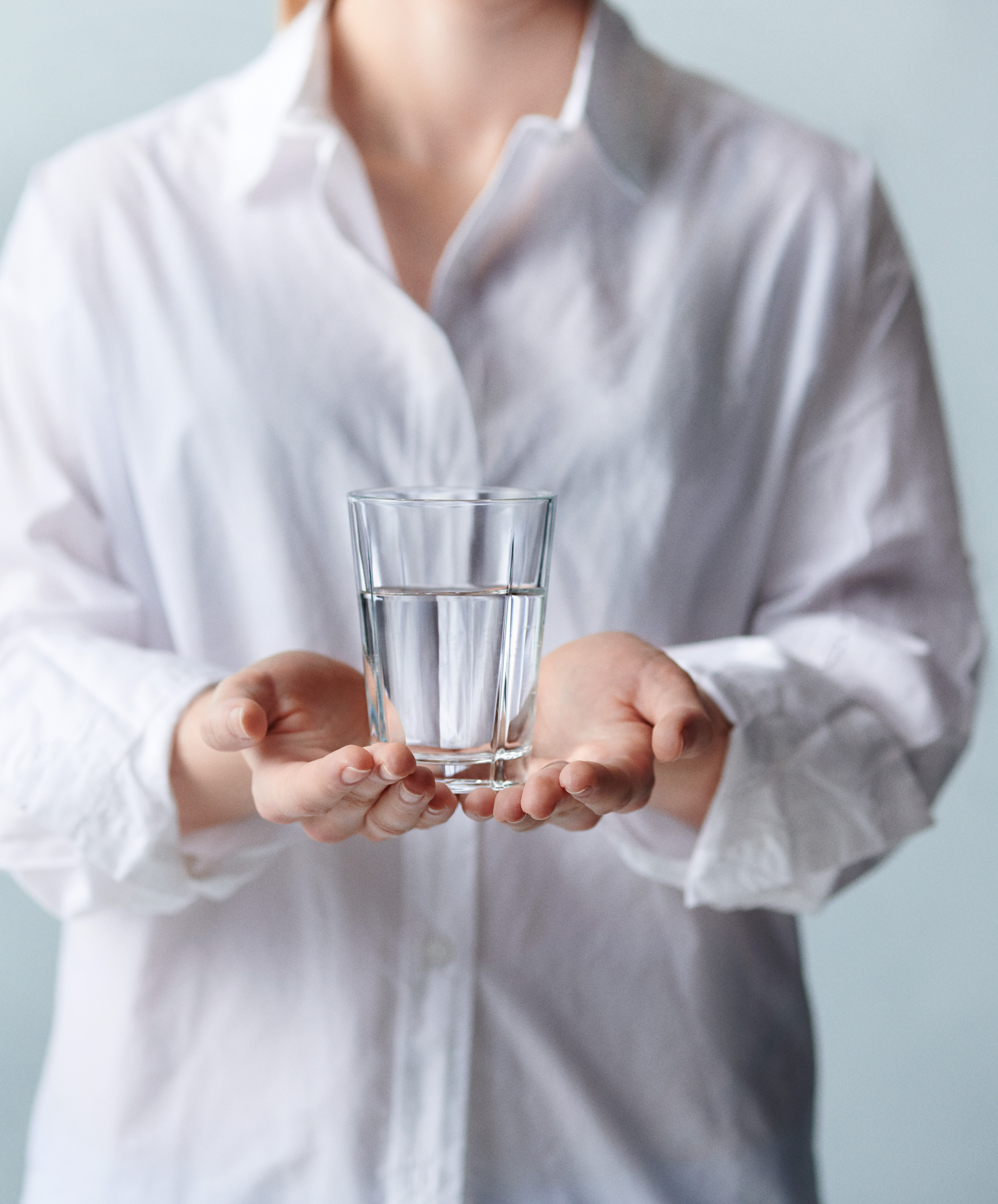 Wasserglas von Rosendahl, Grand Cru, in den Händen einer Frau im weißen Hemd
