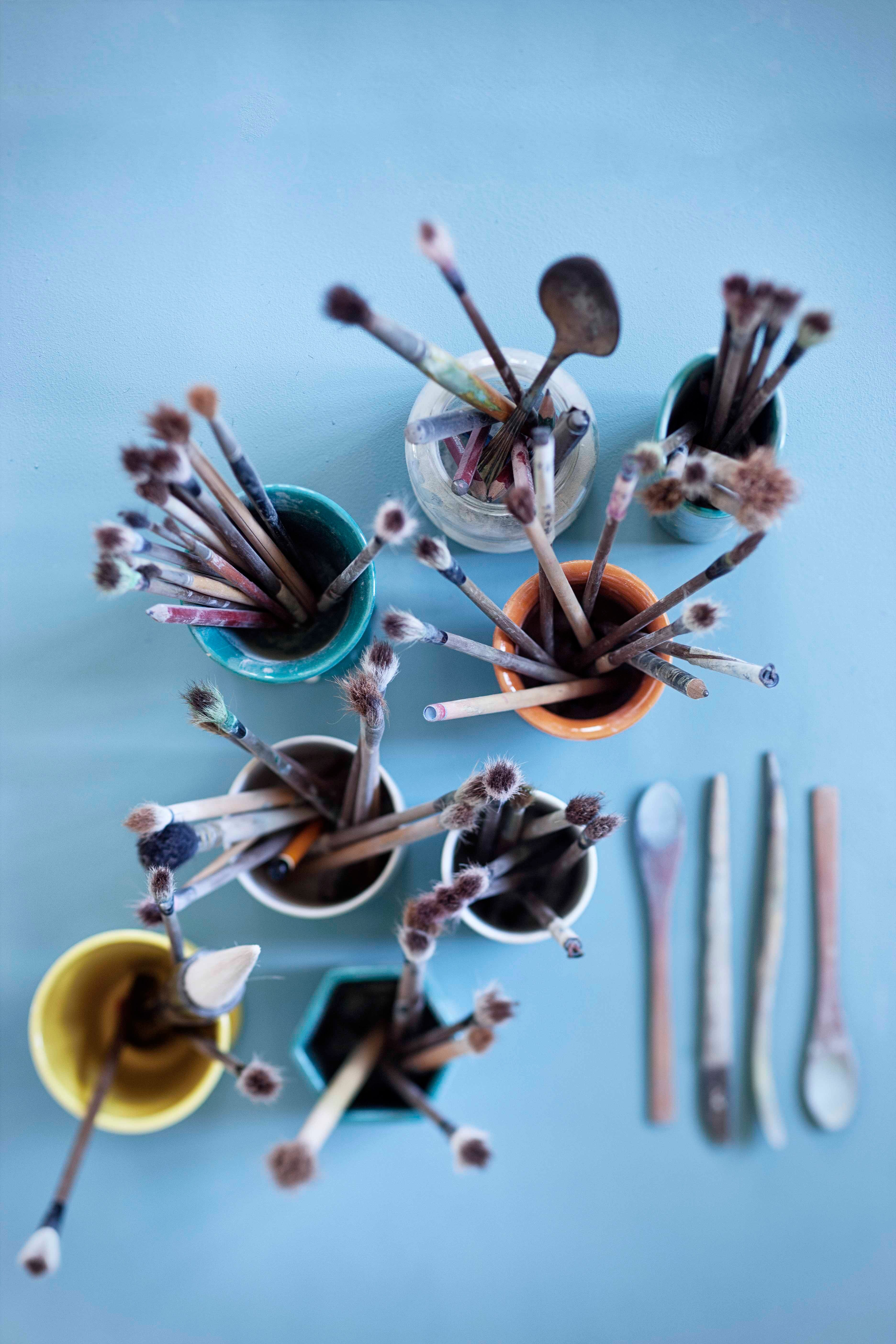 Brushes in mugs seen from above on a table at Bjørn Wiinblad's home