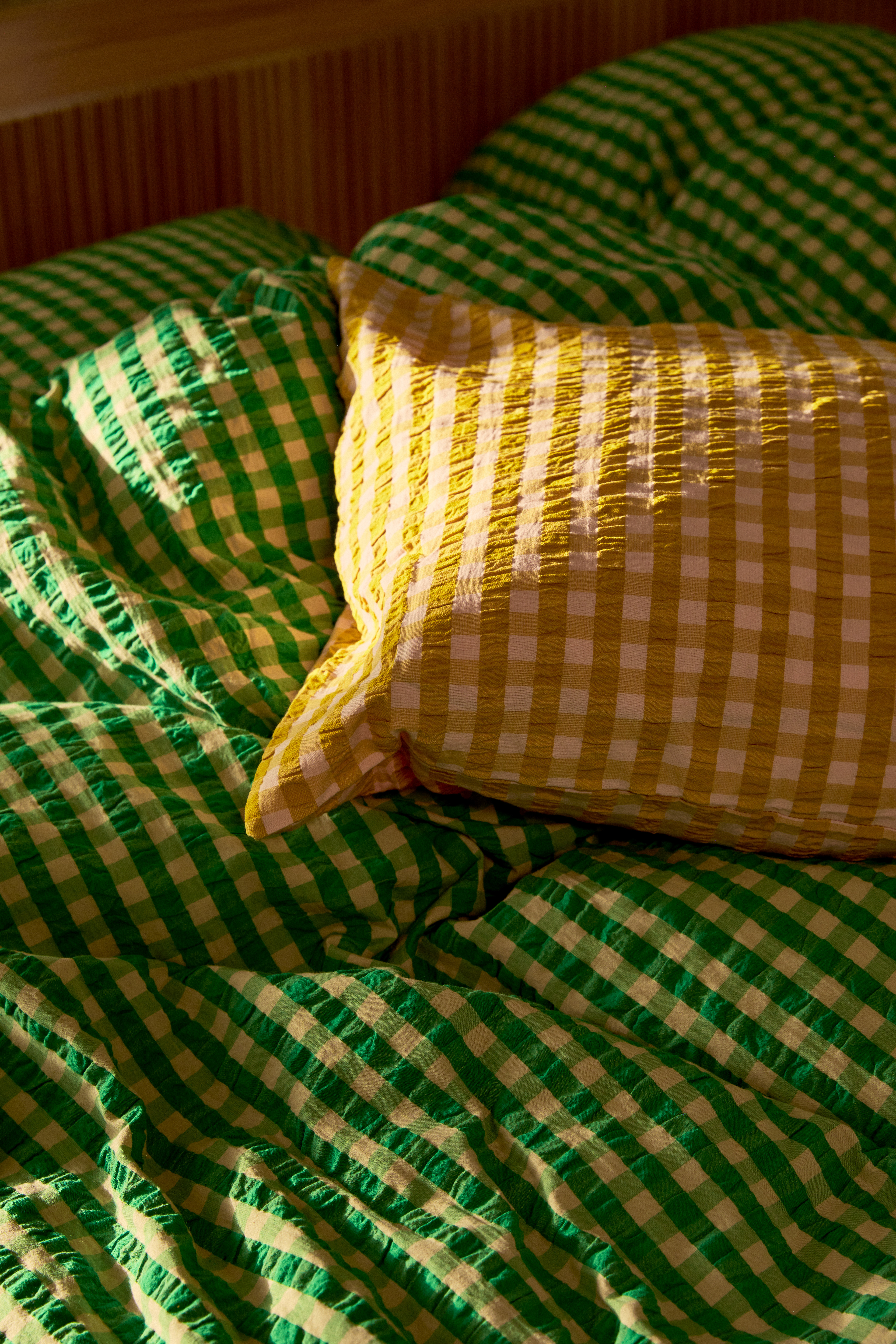 Färgglada sängkläder i grönt och gult från JUNAs serie Bæk&Bølge
