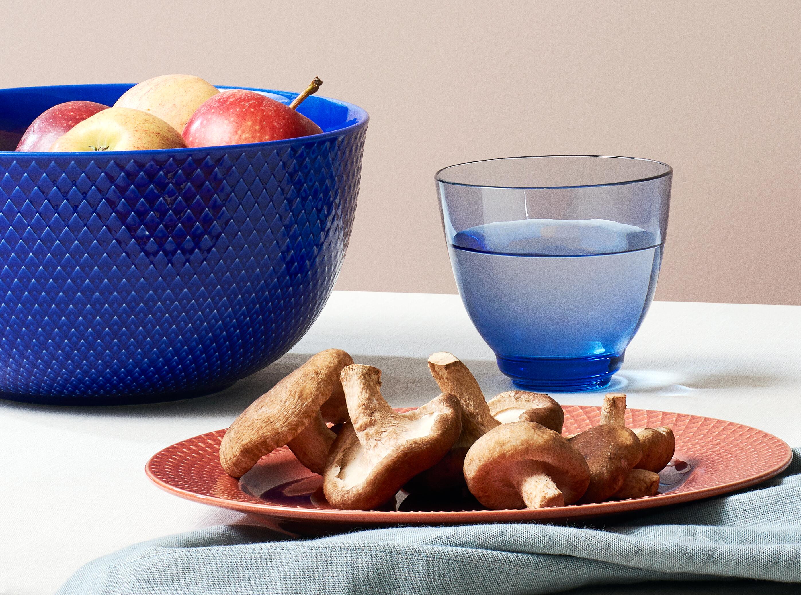 Schalen und Teller in Rhombe Color von Lyngby Porcelæn. Dunkelblaue Schale und weinroter Teller mit blauem Wasserglas