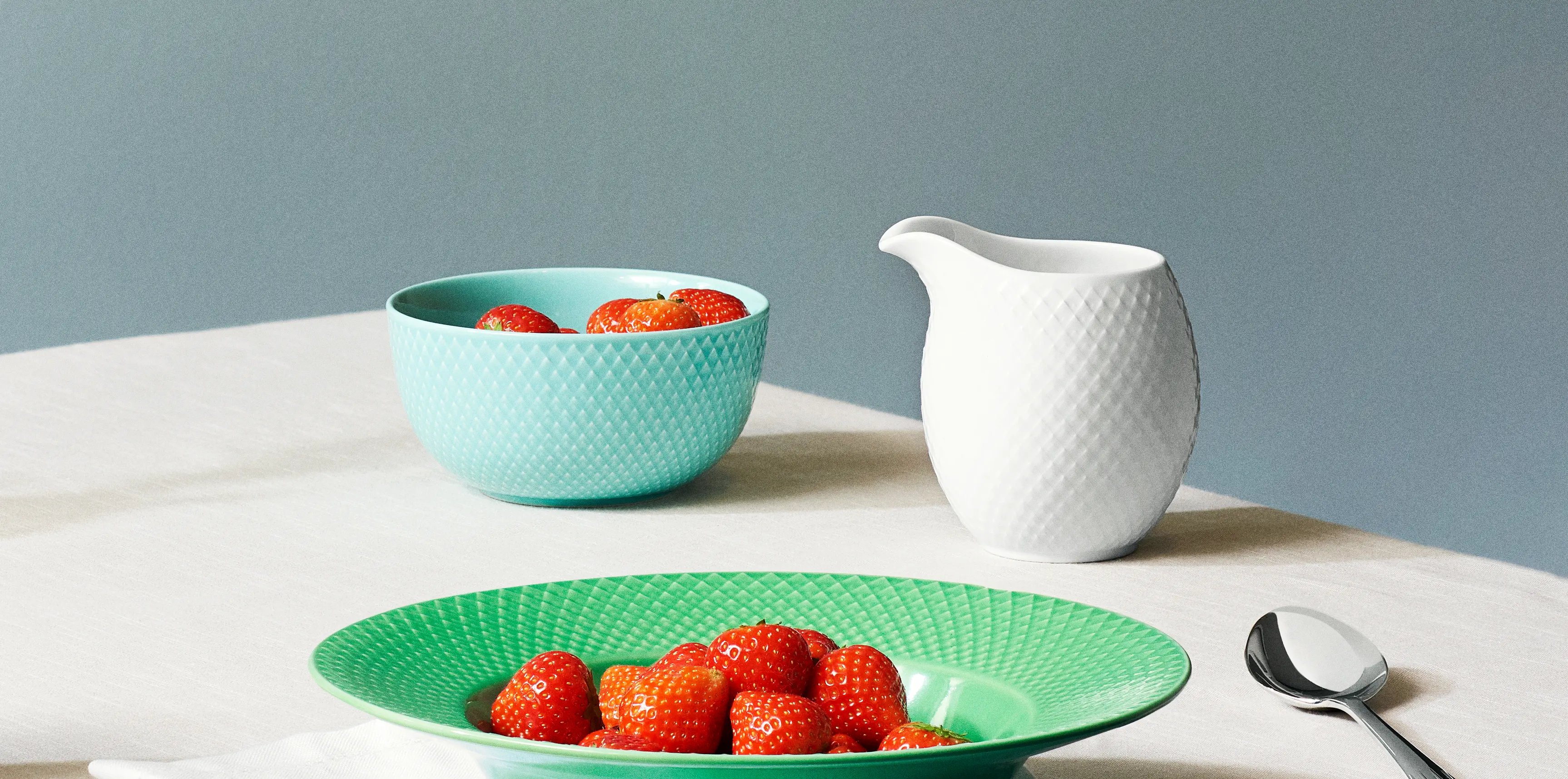 Milk jug in Rhombe from Lyngby Porcelæn. Bowl in turquoise and green porcelain from the Rhombe Colour collection