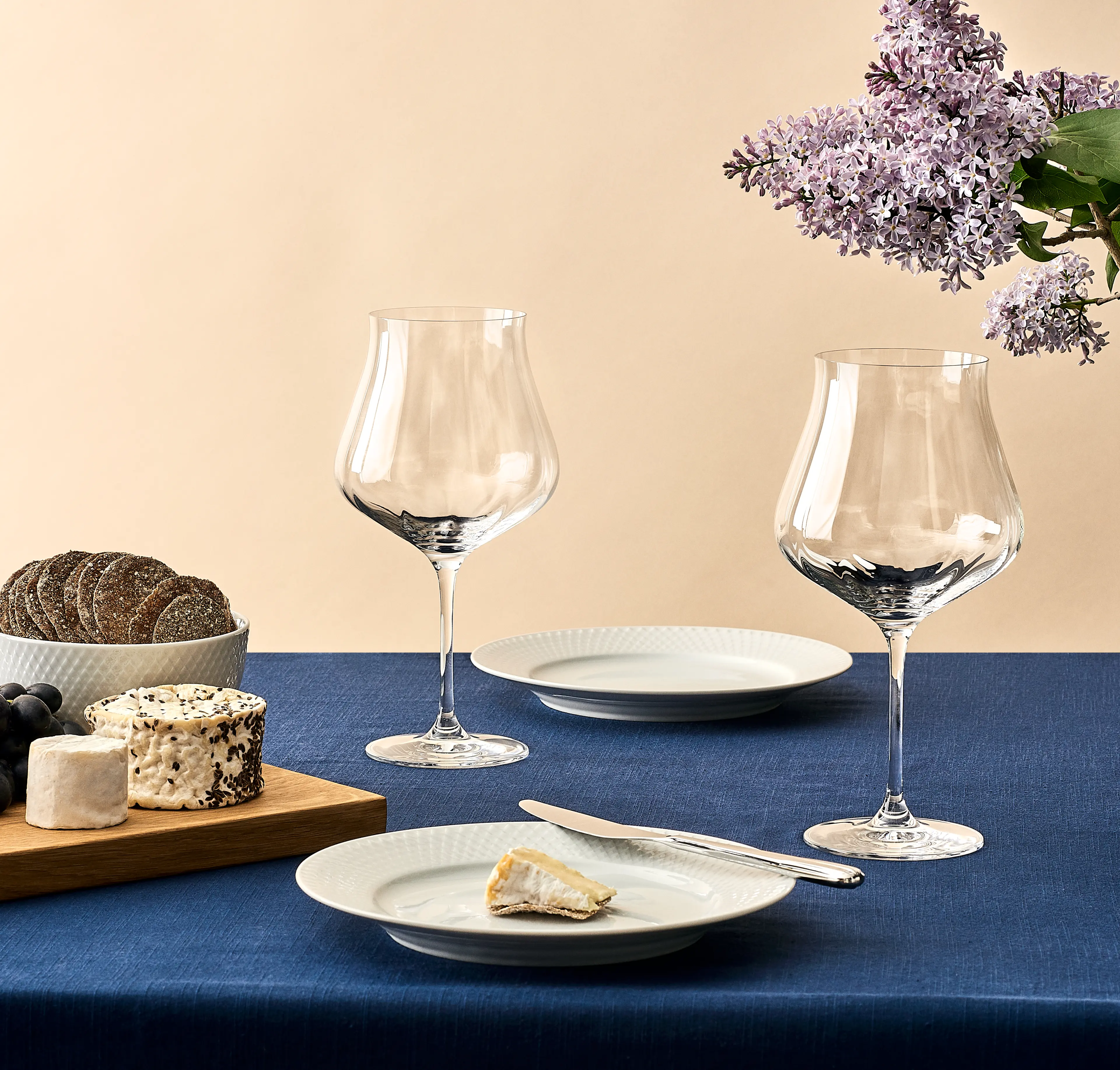 To herlige rødvinsglass på et ostebrett