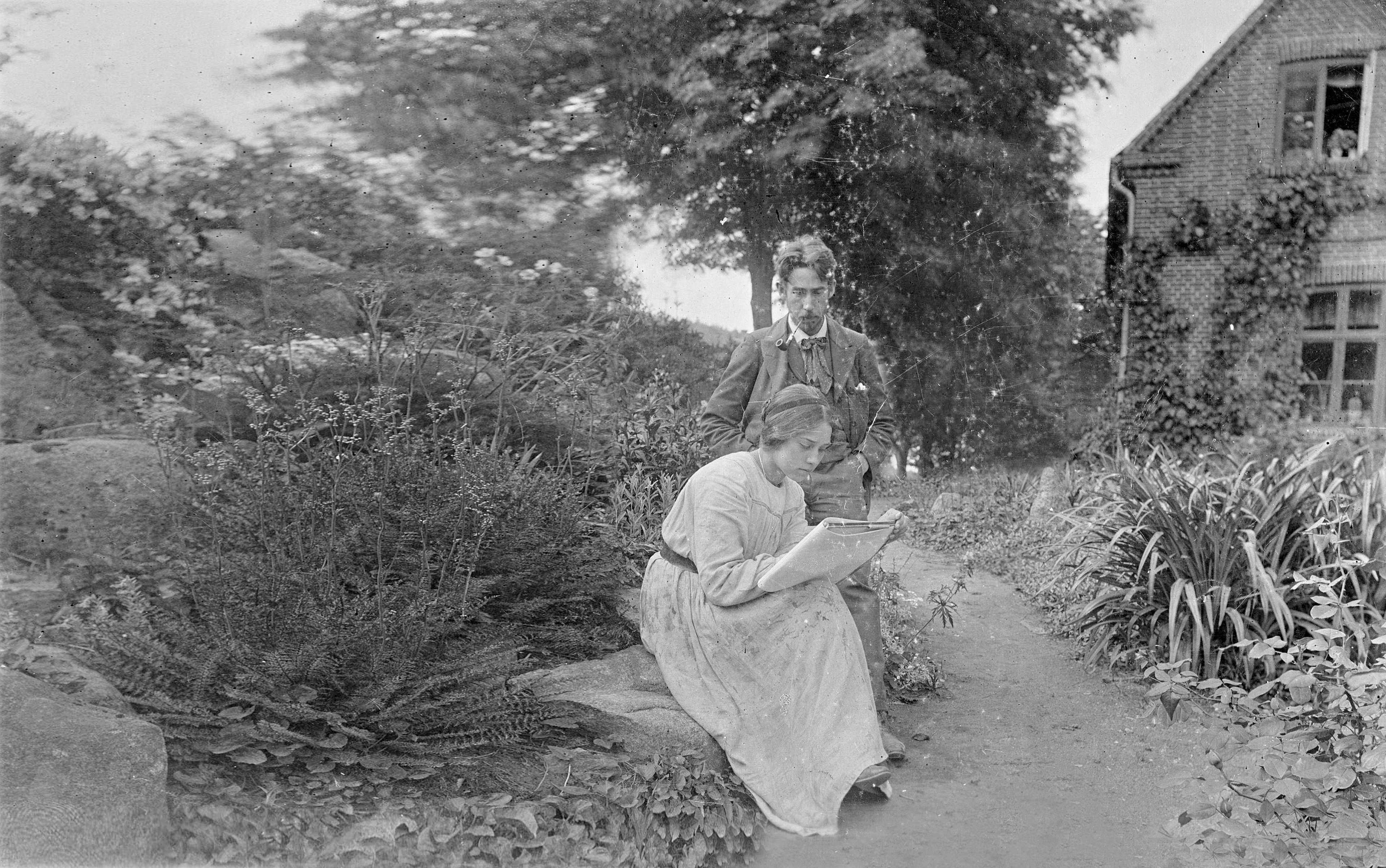 Stella Kähler, a painter at Kähler, reads a book in the garden with her husband, Herman August Kähler