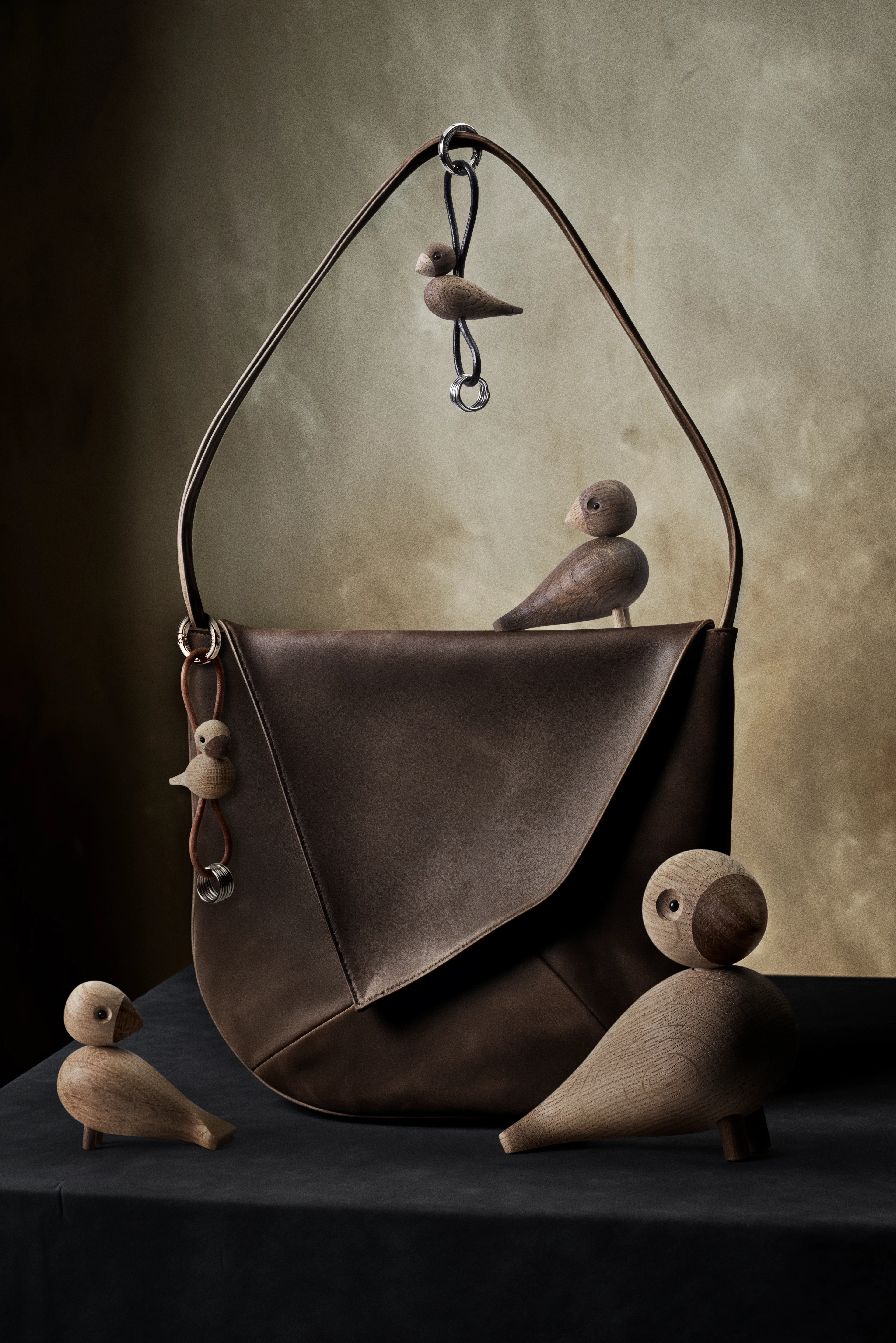 Fågel gull tonet metall nyckelring med naturläder från Kay Bojesen i färgen Ek, tillverkad av Trä