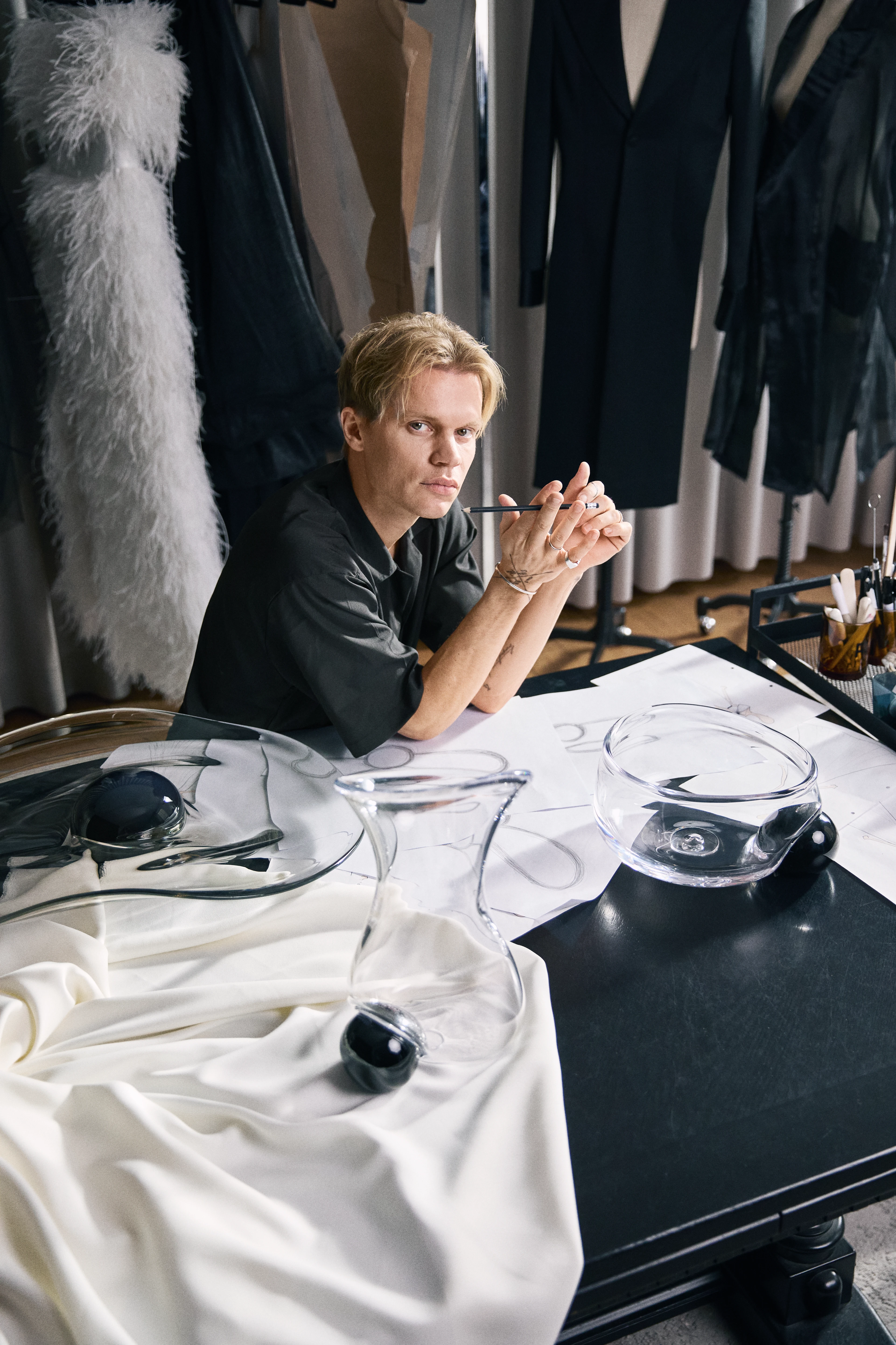 Holmegaard Silhouette, Soeren Le Schmidt, Sitting at a table surrounded by Holmegaard's 200th anniversary products