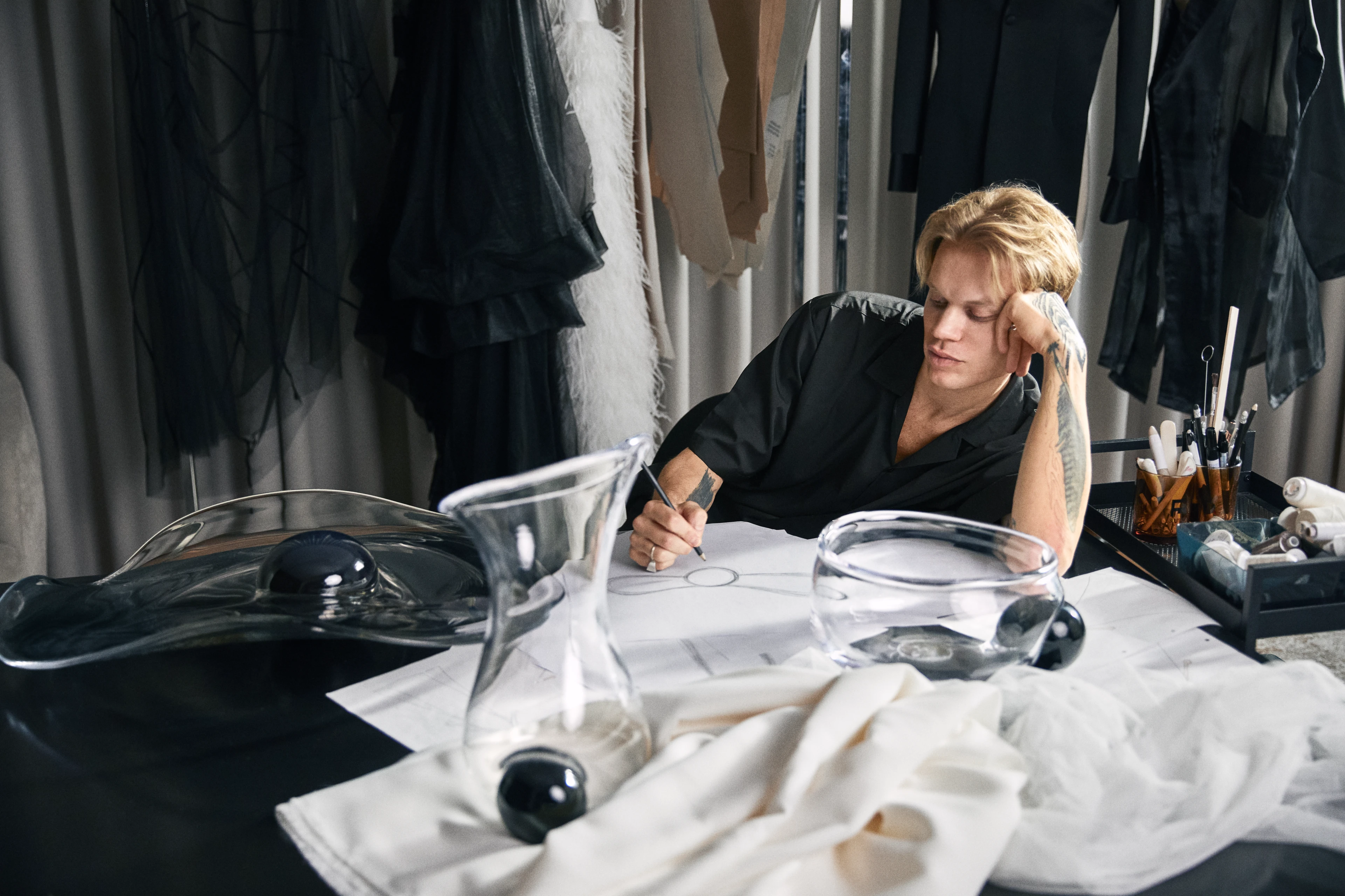 Holmegaard Silhouette, Soeren Le Schmidt, Sitter ved bordet omgitt av Holmegaards 200-årsjubileumsprodukter