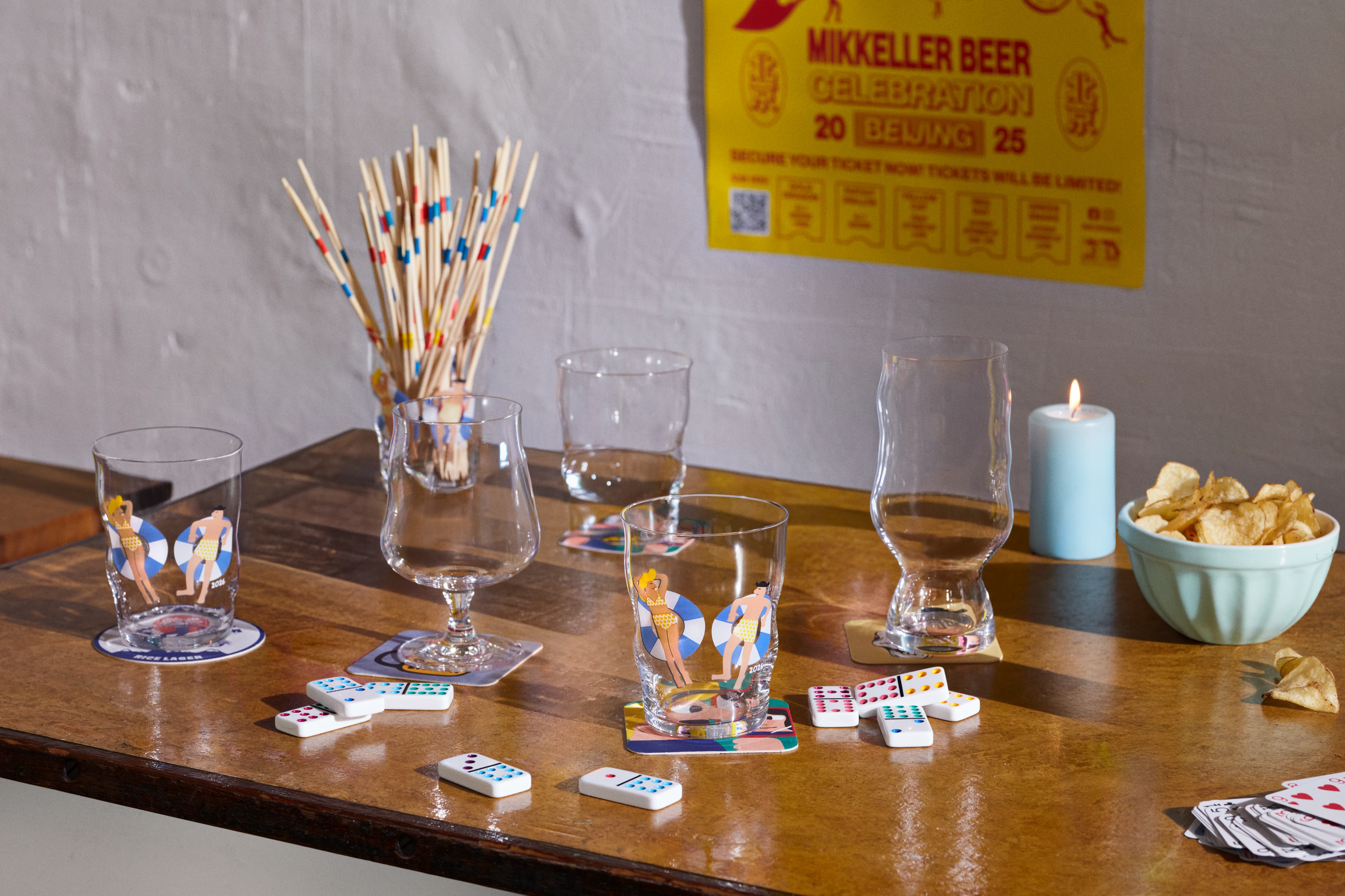 Spillebord med kort, snacks og Holmegaard x Mikkeller ølglas i avslappet stemning.