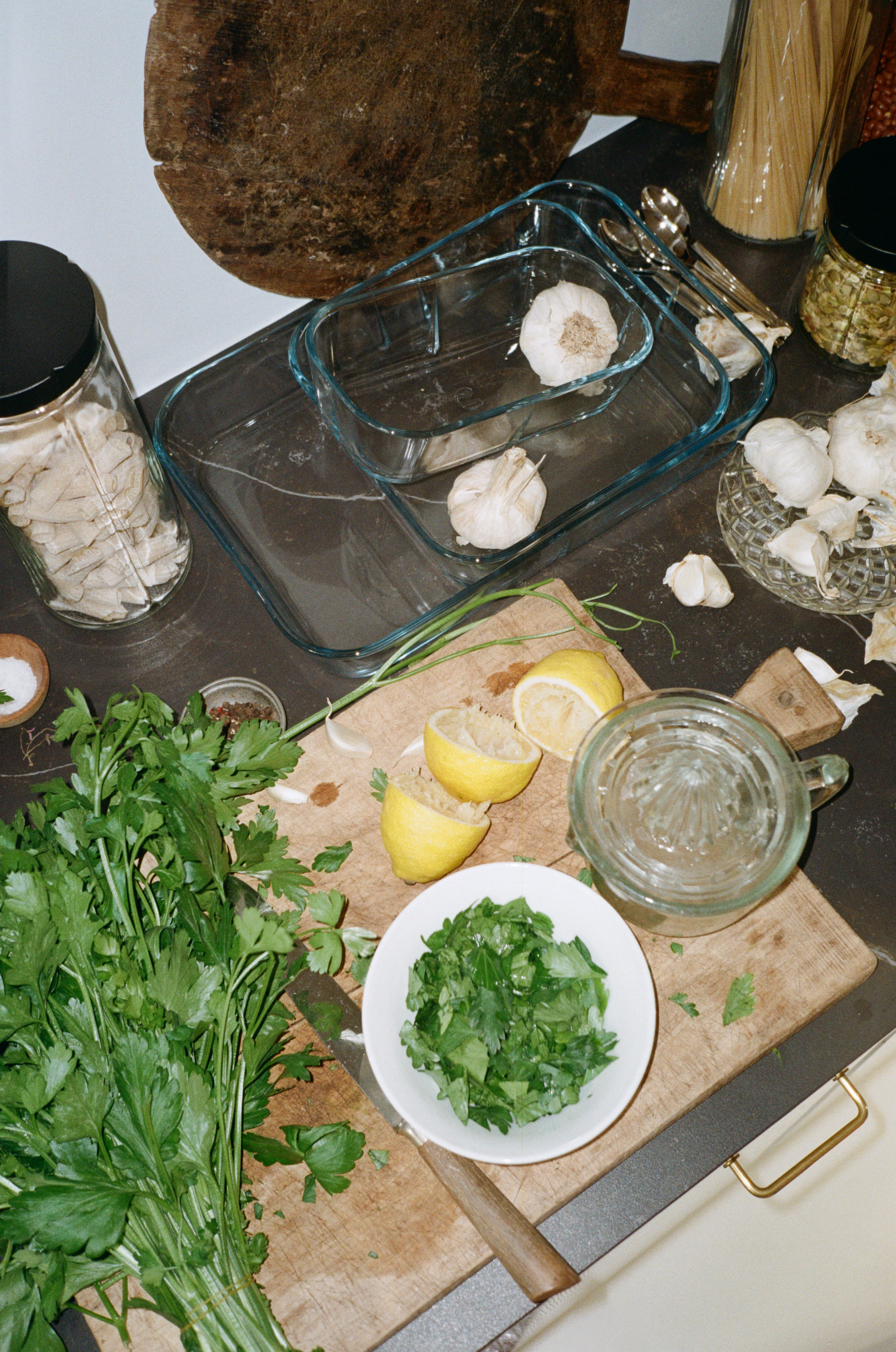 Rosendahl køkkenopstilling med glasfade, hvidløg, citron, krydderurter og olie på træbord