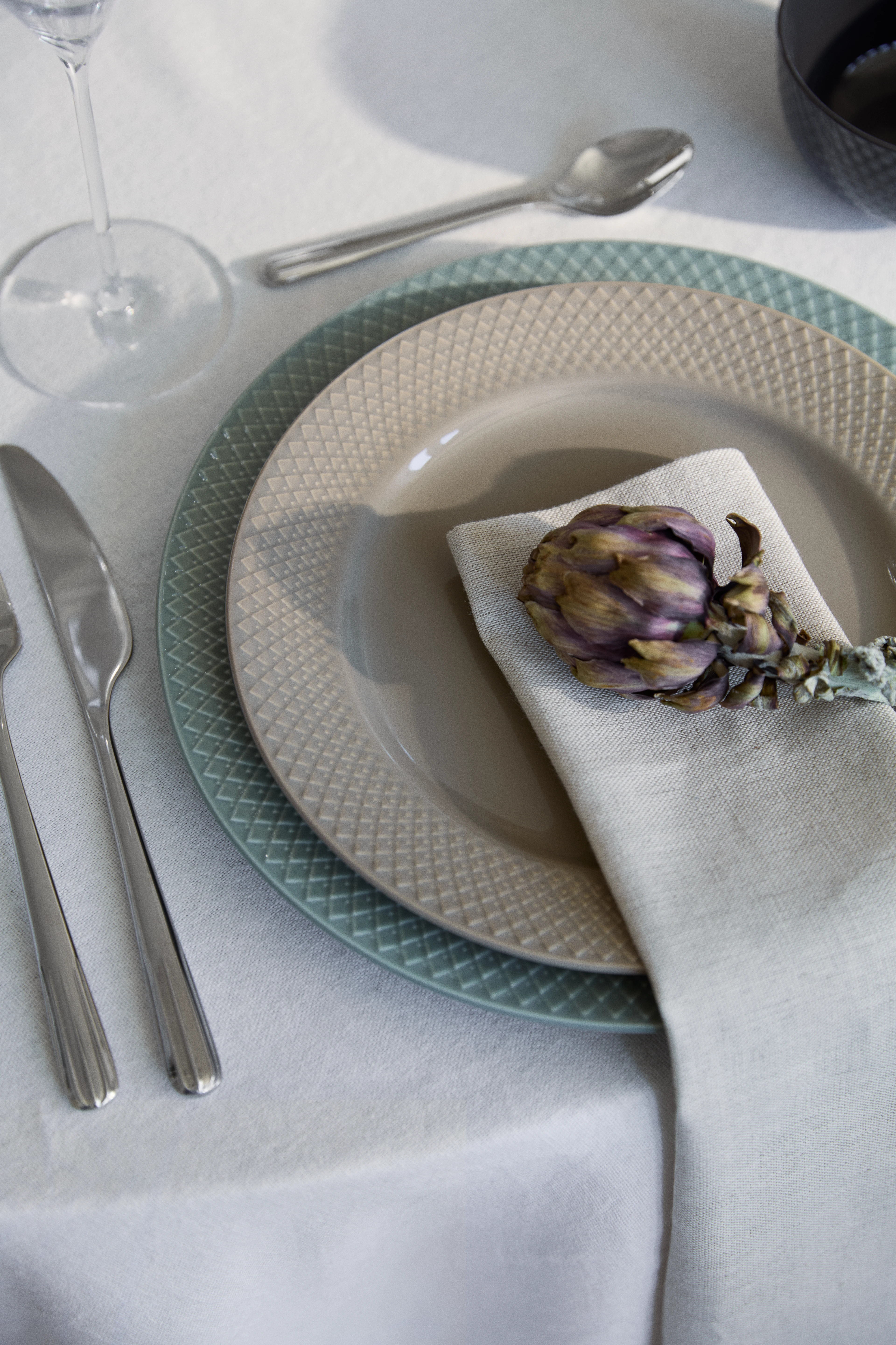 Lyngby Rhombe Earth plate with textured pattern, table setting with napkin and decorative flower