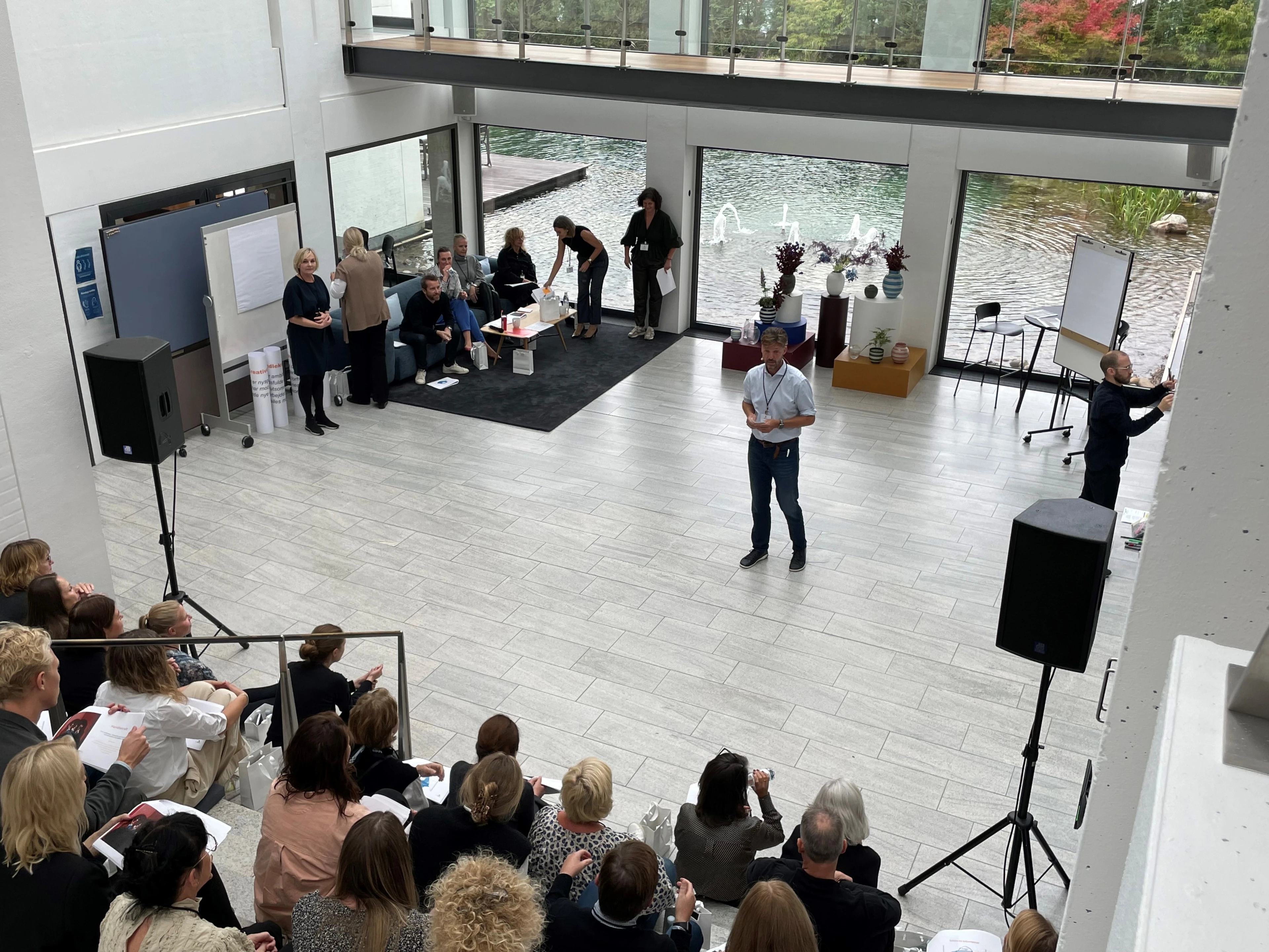 Henrik Rosendahl speaks to a group of employees seated on a staircase, attentively listening