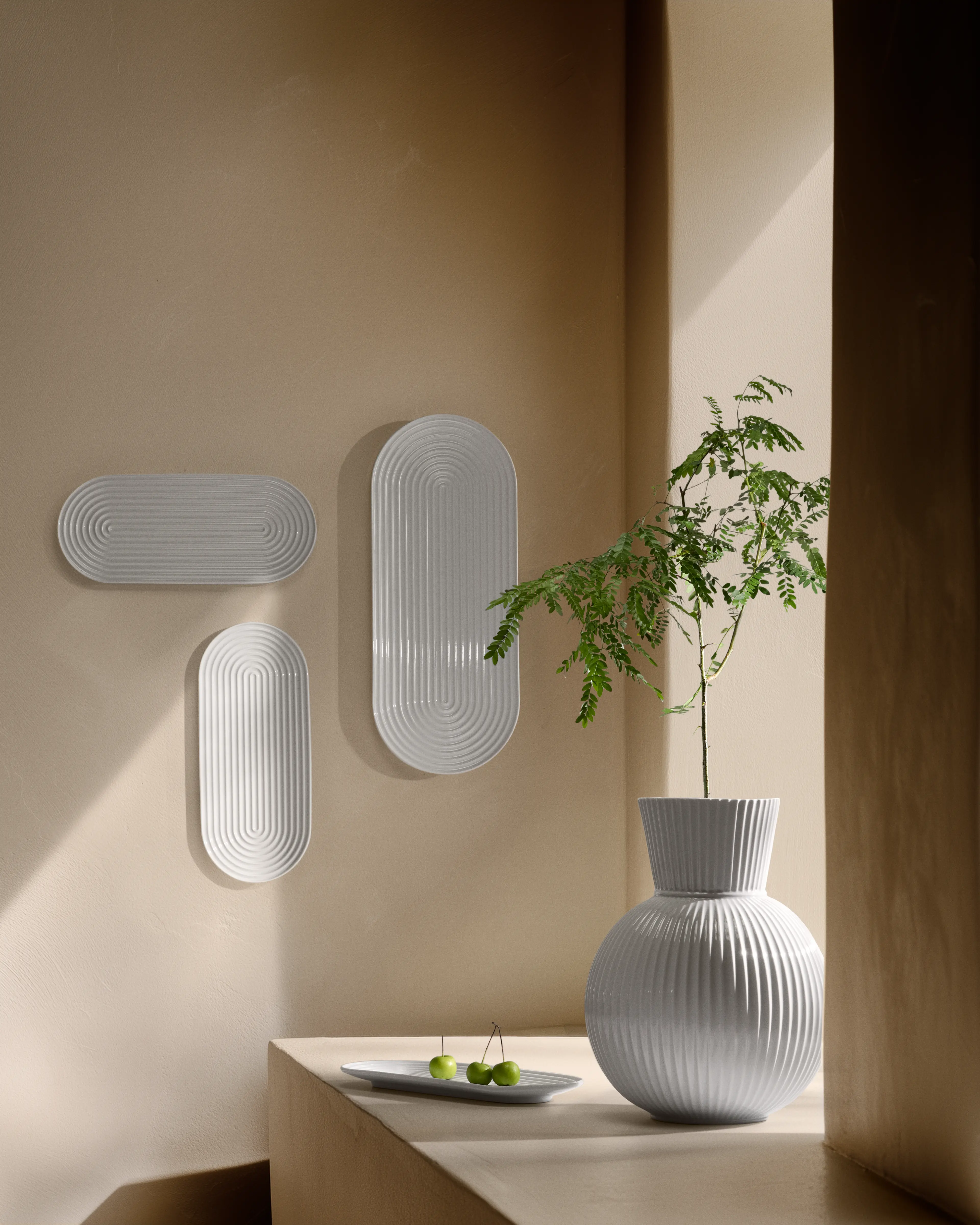 Lyse vaser og vægrelief i stilleben med grøn gren fra lyngby Porcelæn Lyngby Tura serie.