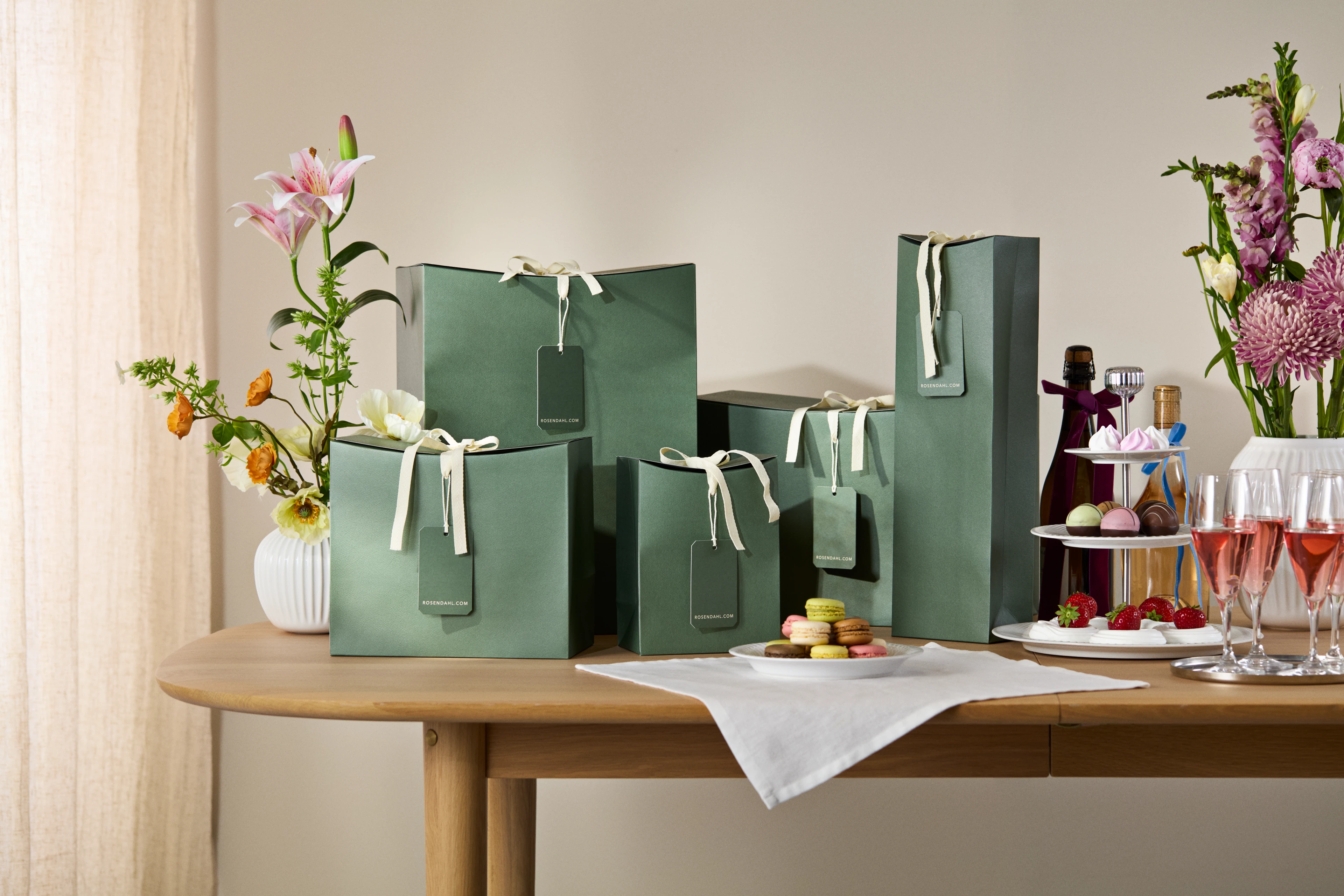 Stilleben med elegante gaveesker, keramikk og blomster på bordet – inspirerende gaveguide til enhver anledning.