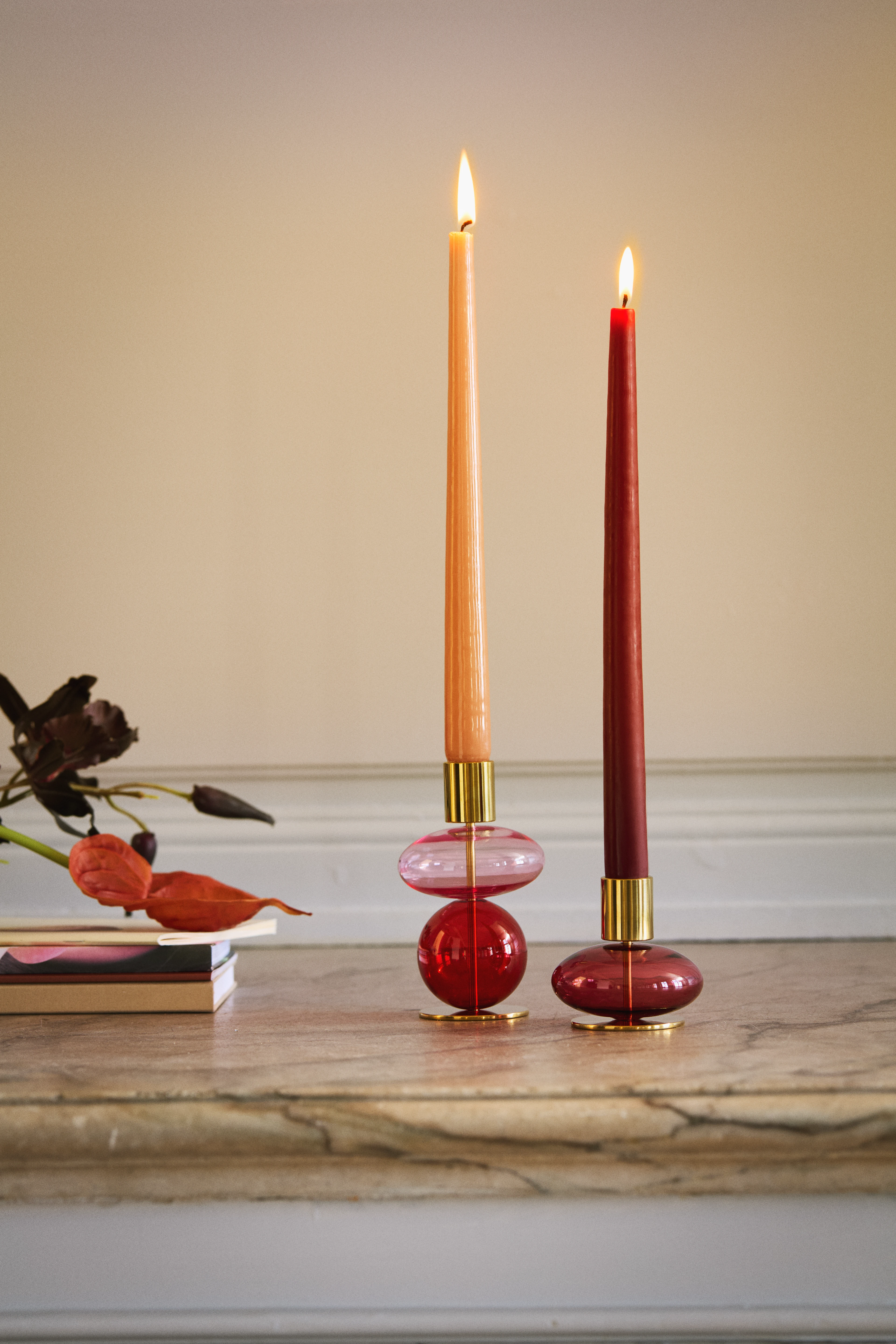 Holmegaard Bubble candle holders in pink glass with tall taper candles on a marble table