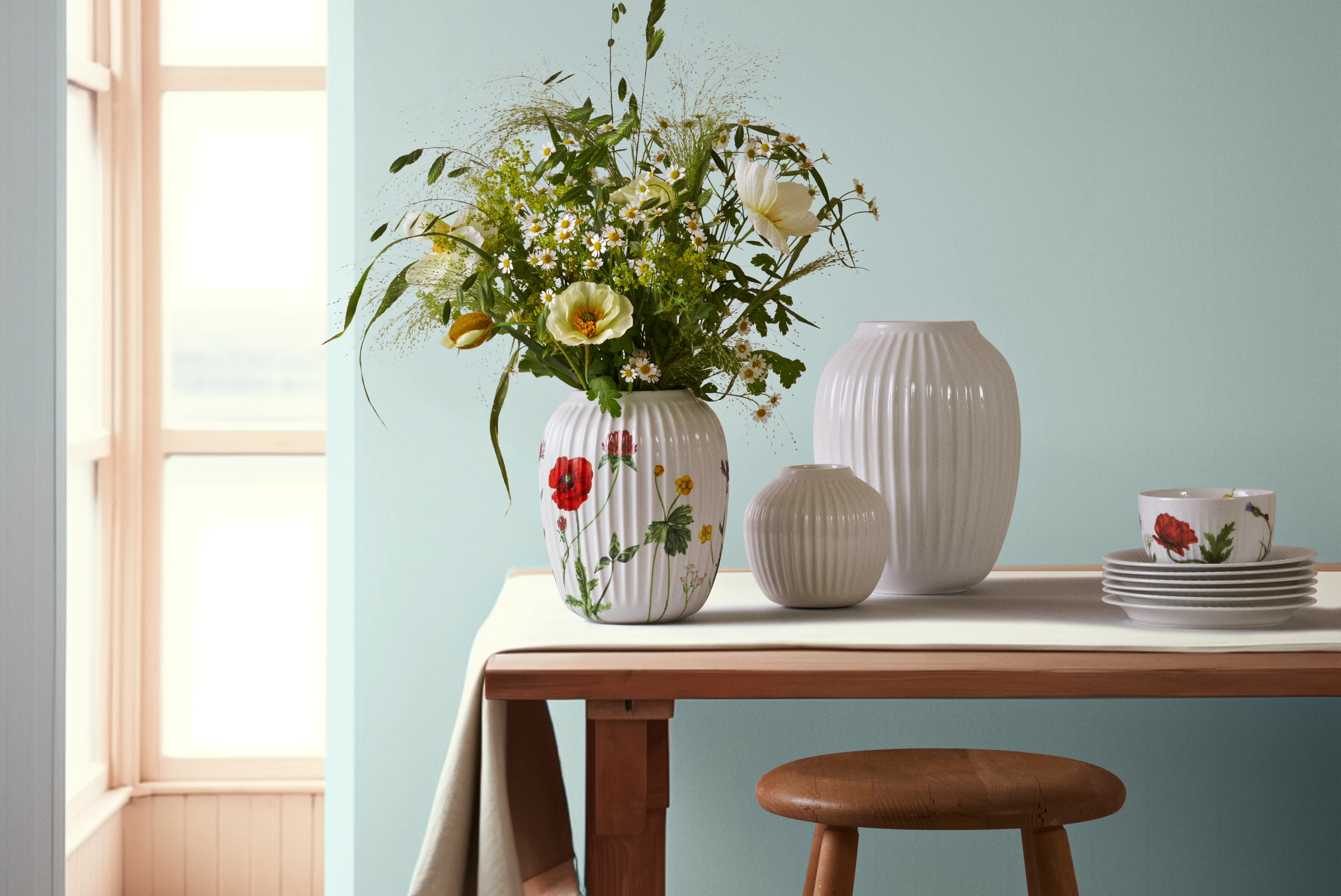 Kähler Hammershøi vase med blomster på bord, stilrent dansk design i lyse farver