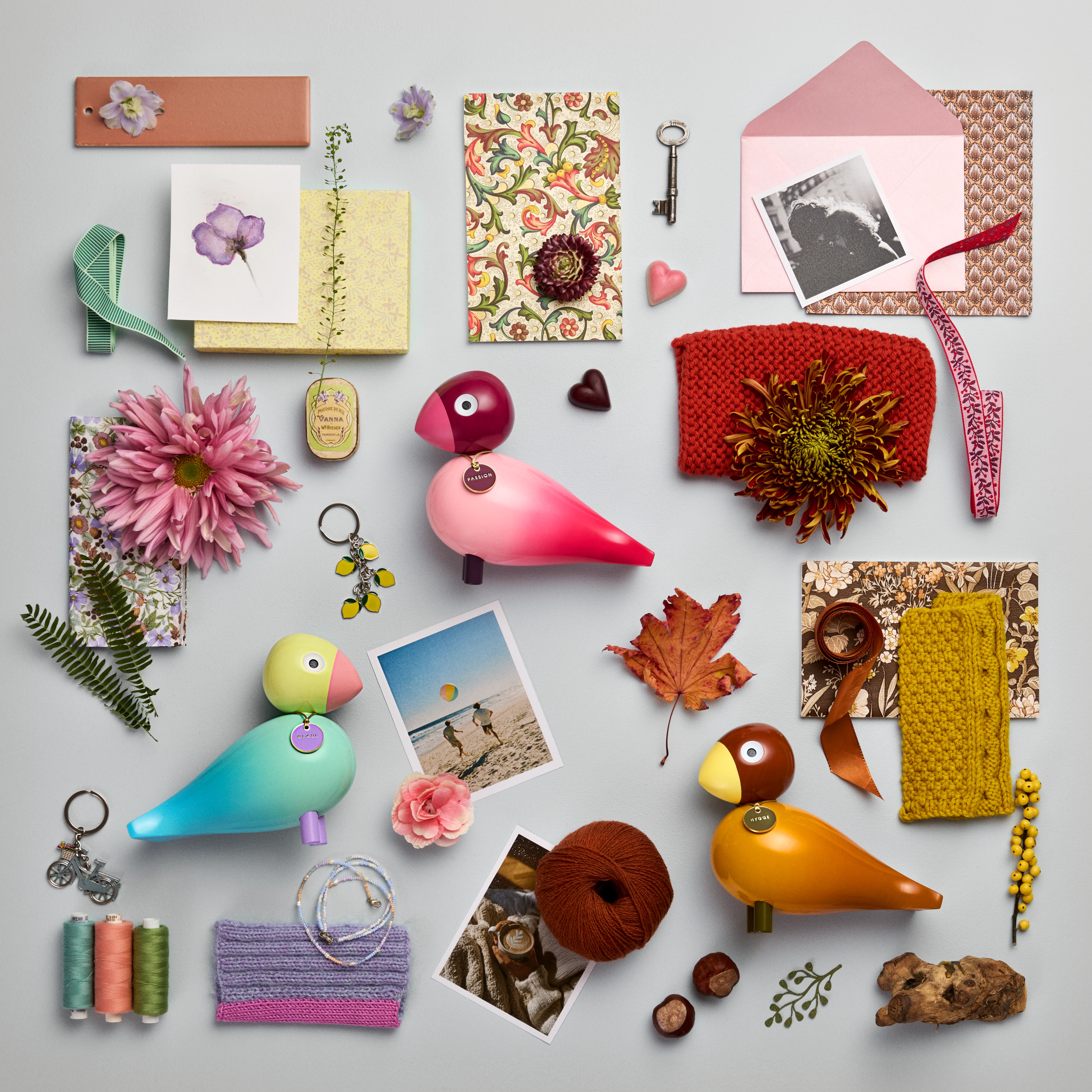 Kay Bojesen Story Birds i farverigt flatlay med fugle, fotos og tekstiler inspireret af livets store følelser