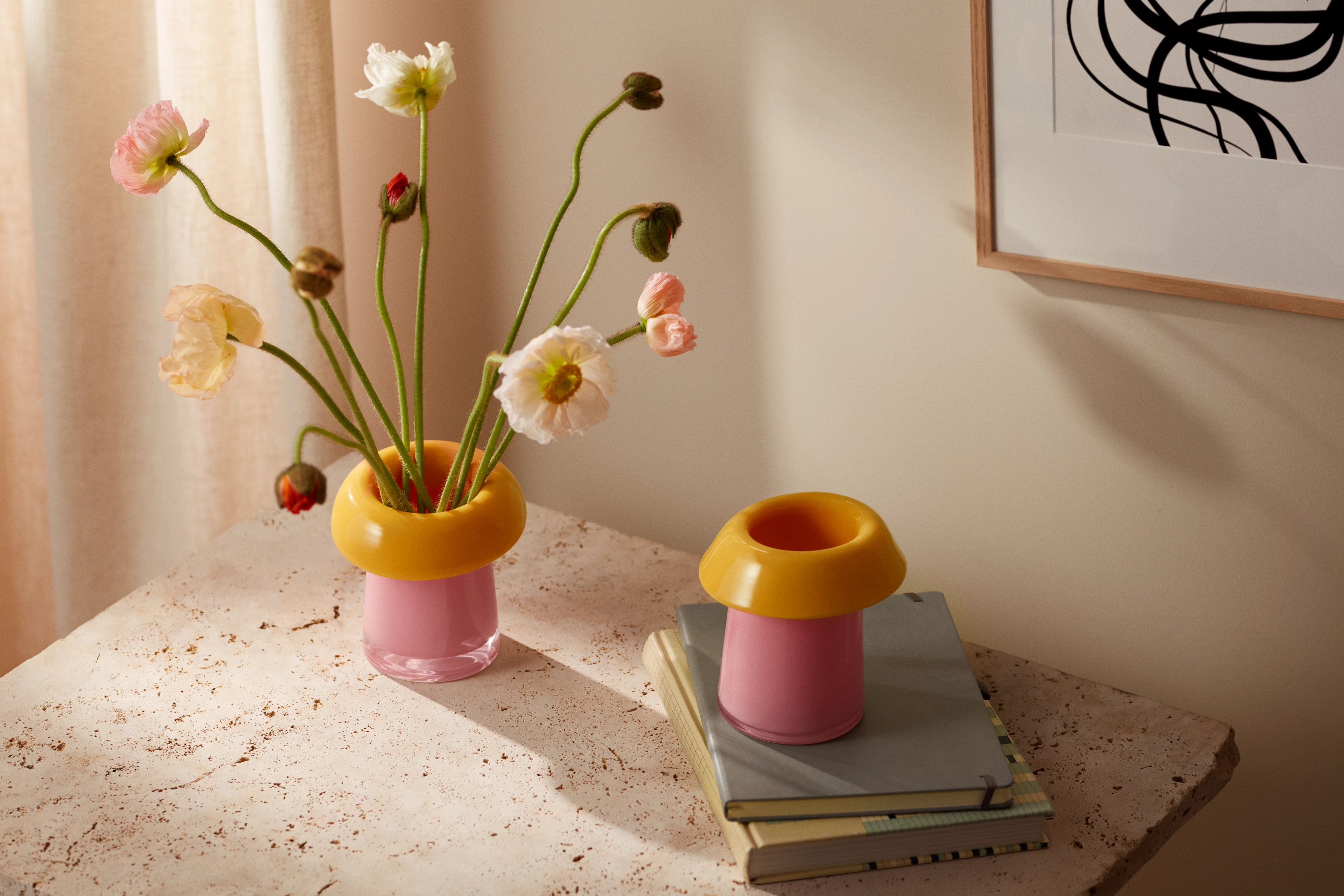 Holmegaard Soma Vasen in Pink und Gelb mit Blumen auf einer Steinfläche in hellem, modernem Ambiente.