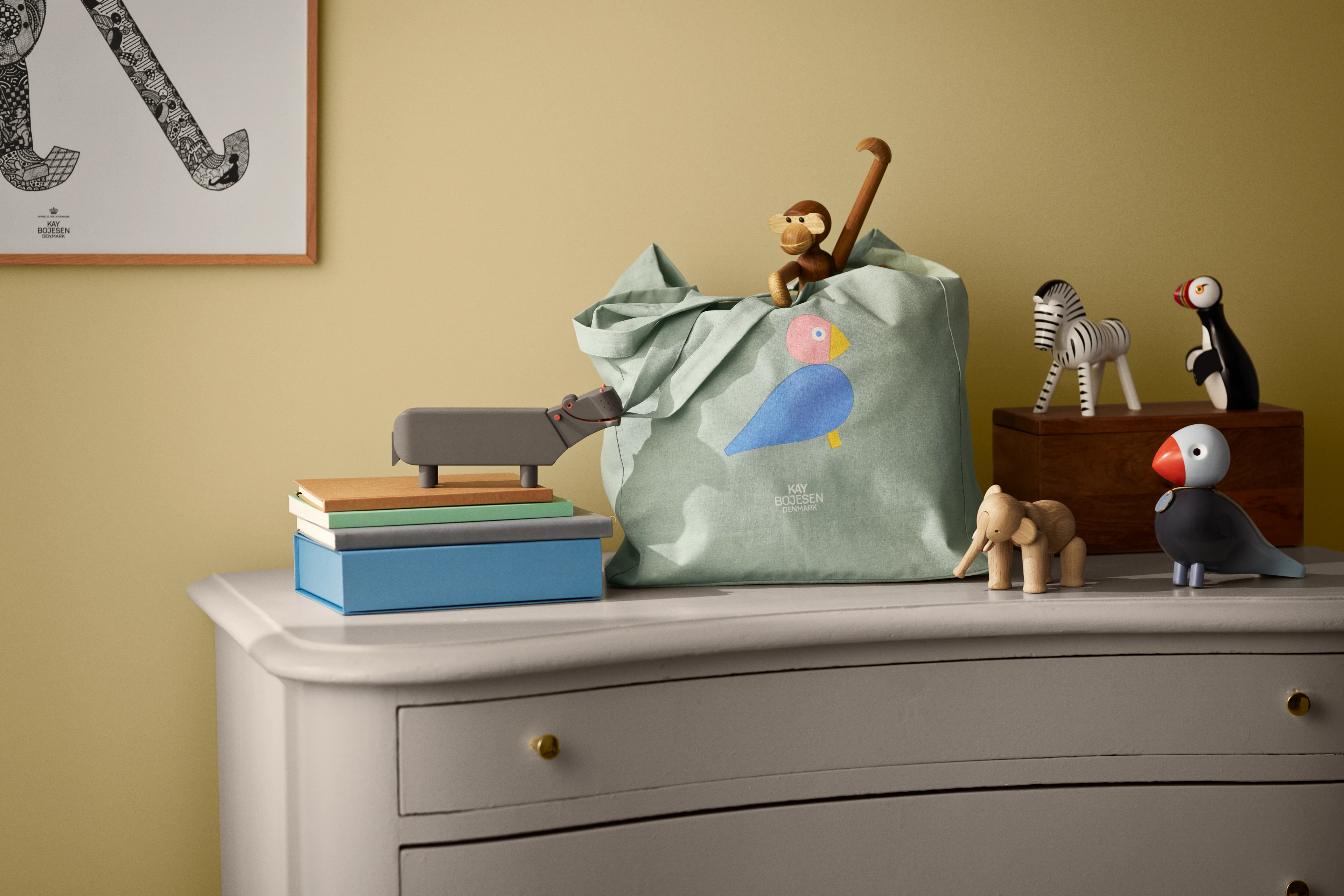 Kay Bojesen figures in a kids room with bag, toys and books on a dresser