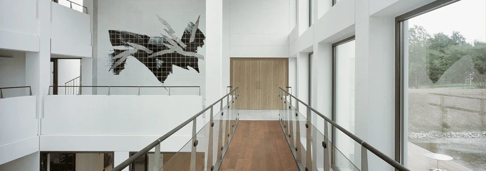 Inside Rosendahl Design Group, a long hallway with a closed door at the end and artwork displayed on the wall
