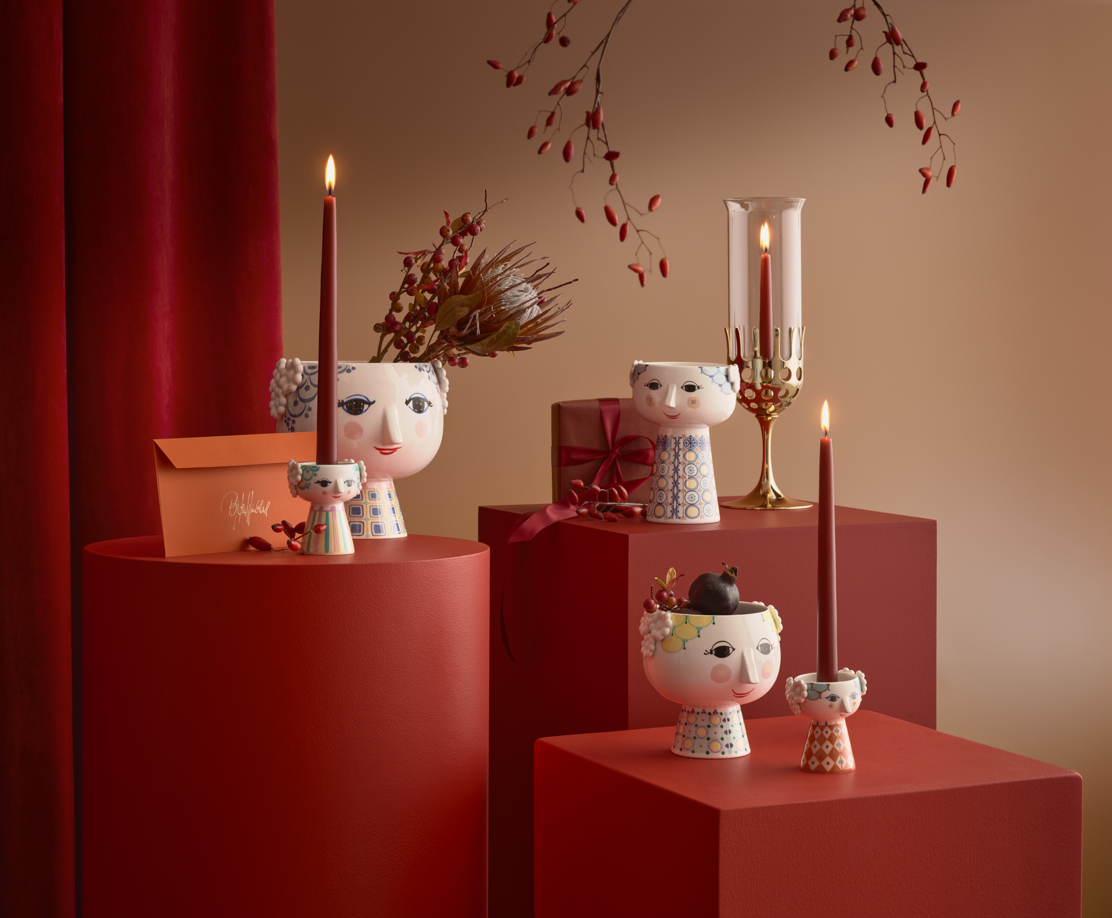 Tre Eva-vaser fra Bjørn Wiinblad med solsikker sat på bord med bøger