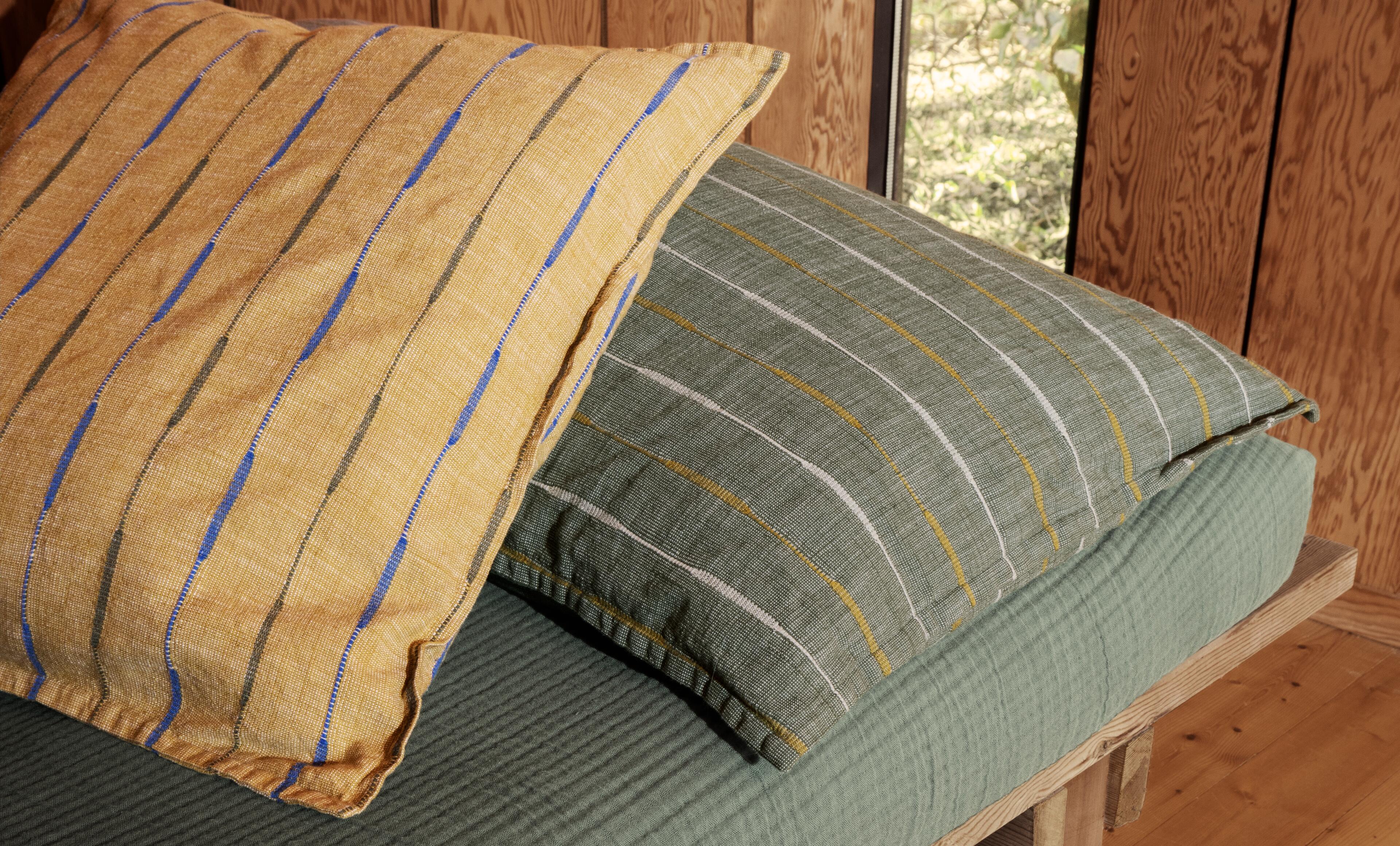 Decorative pillows from JUNA. The pillows are in Bæk og Bølge fabric and are seen in the colors blue, yellow and brown