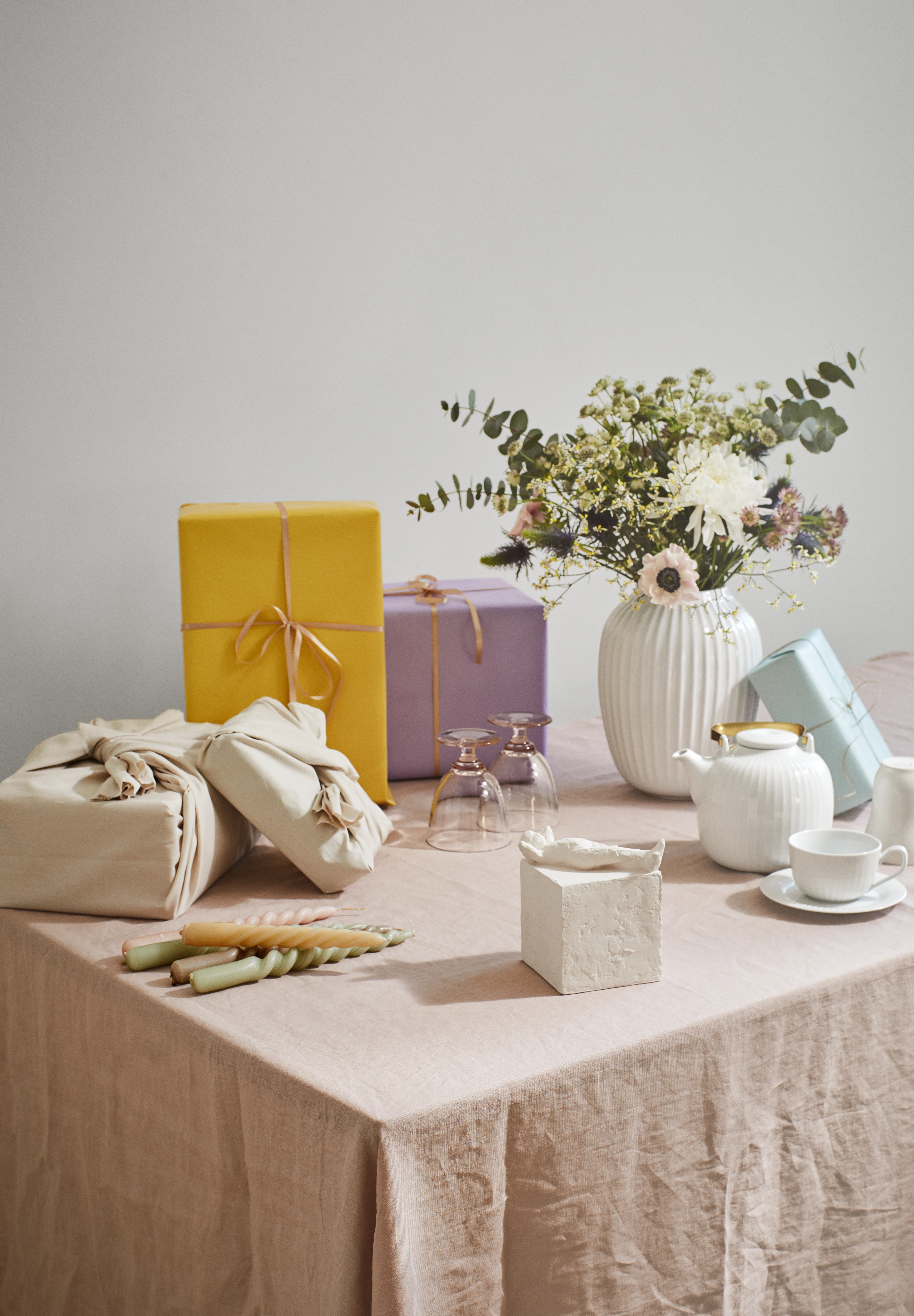 Stillleben mit Geschenkboxen, Keramik und Blumen auf Tisch – elegante Geschenkguide