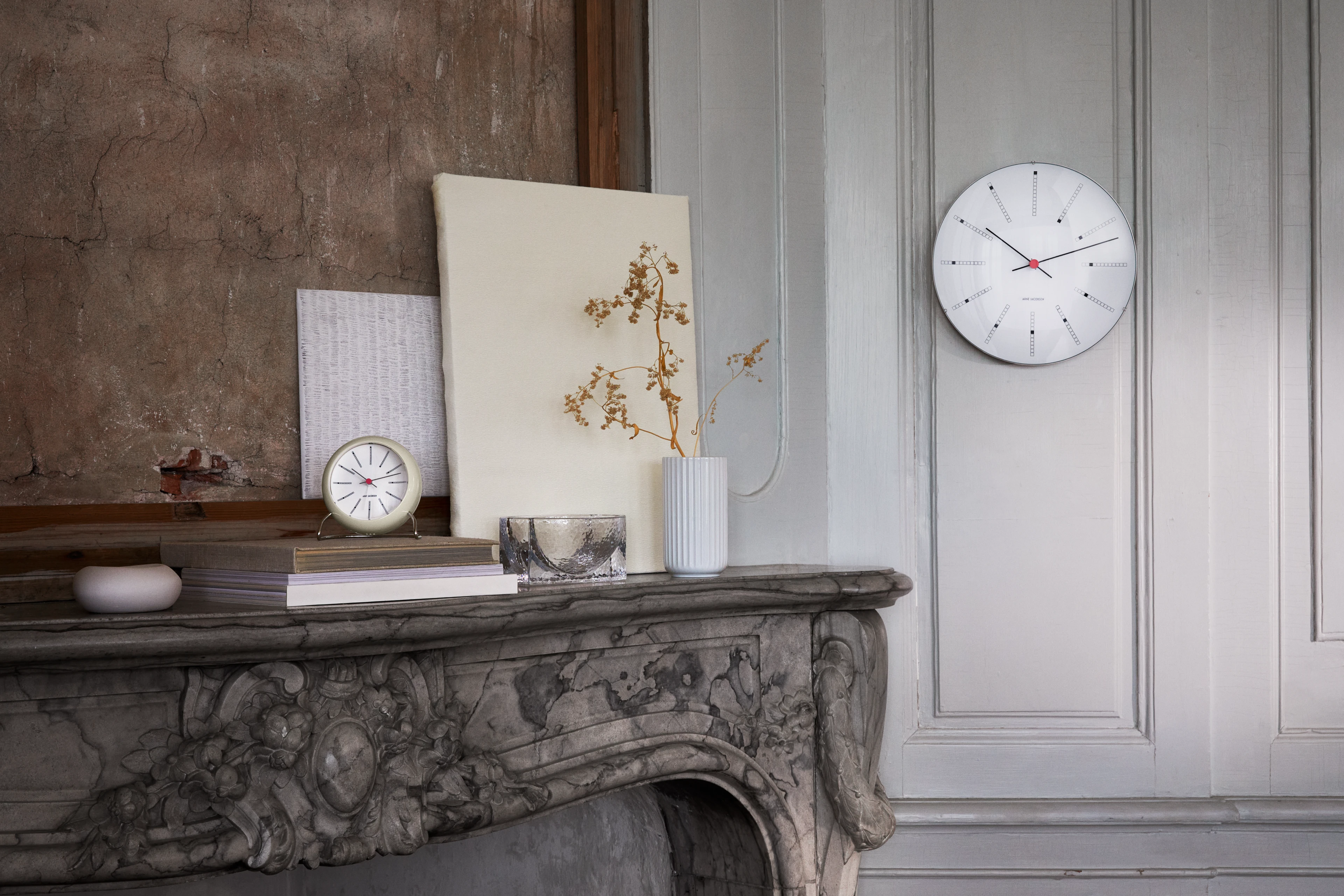 Arne Jacobsen Bankers wall clock and table clock placed on a fireplace